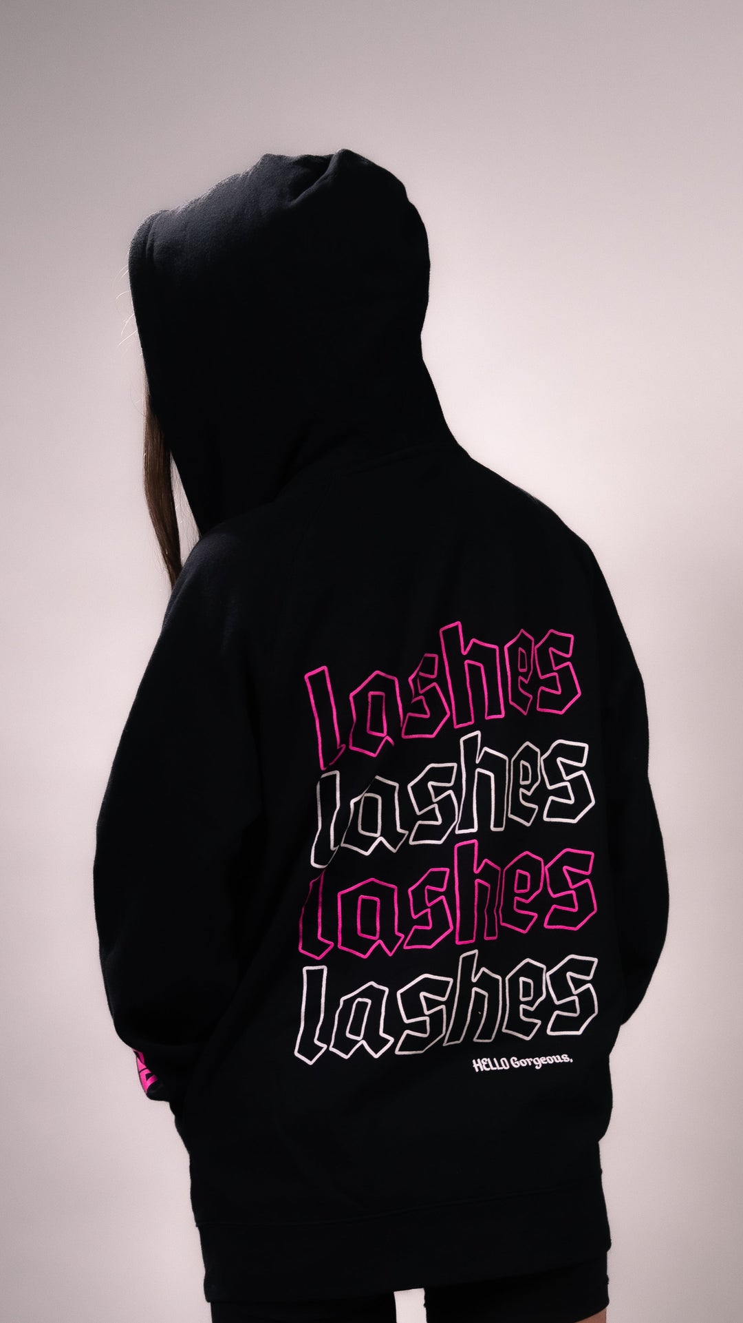PLA Lash Sweater, Black Zip Up (back view of the sweater, lashes lashes lashes design with hello gorgeous on the bottom right)