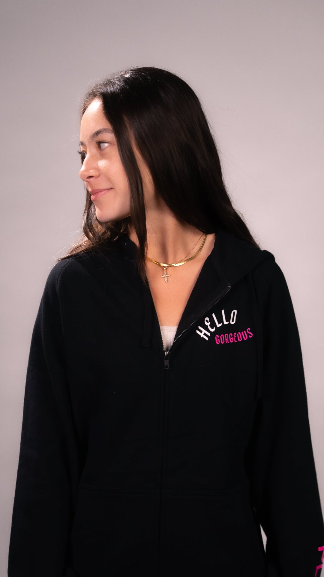 PLA Lash Sweater, Black Zip Up (front view of the sweater on a person, hello gorgeous design on left chest area and PLA logo on the bottom left sleeve)